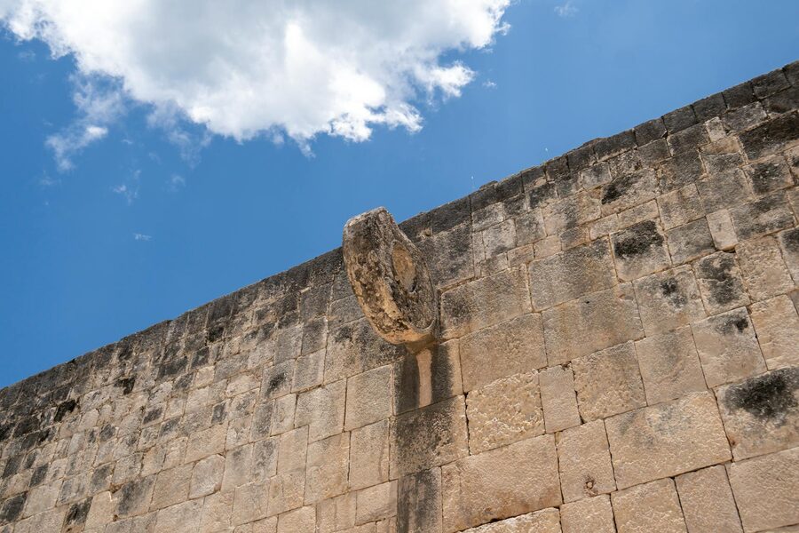 A stone hoop at the Chichen Itza ball court against a blue sky