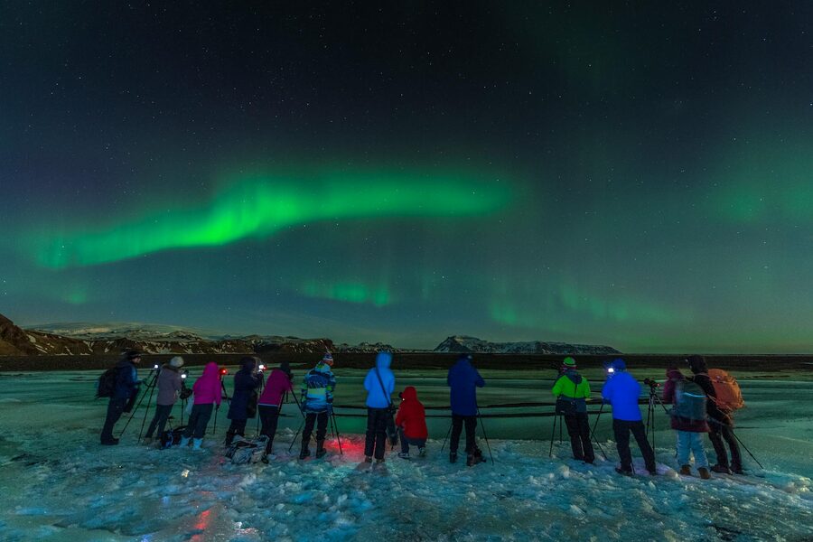 A group of people watching aurora borealis over Iceland