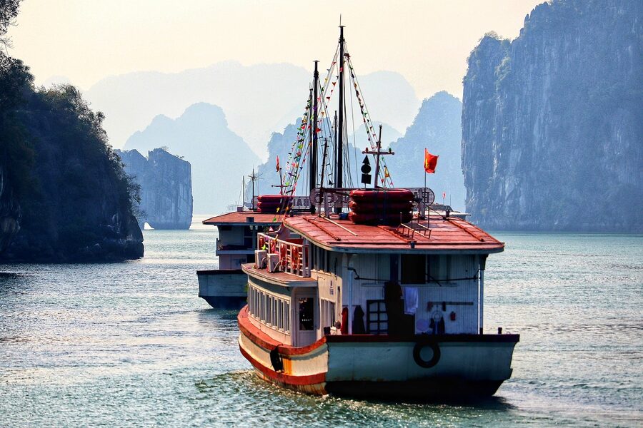 A traditional Vietnamese junk boat sailing through the karst islands of Halong Bay