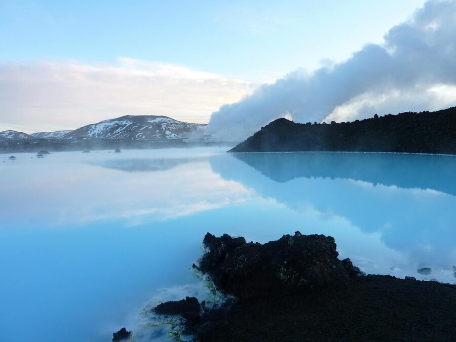 Steaming geothermal waters at the Blue Lagoon in Iceland with distant mountains