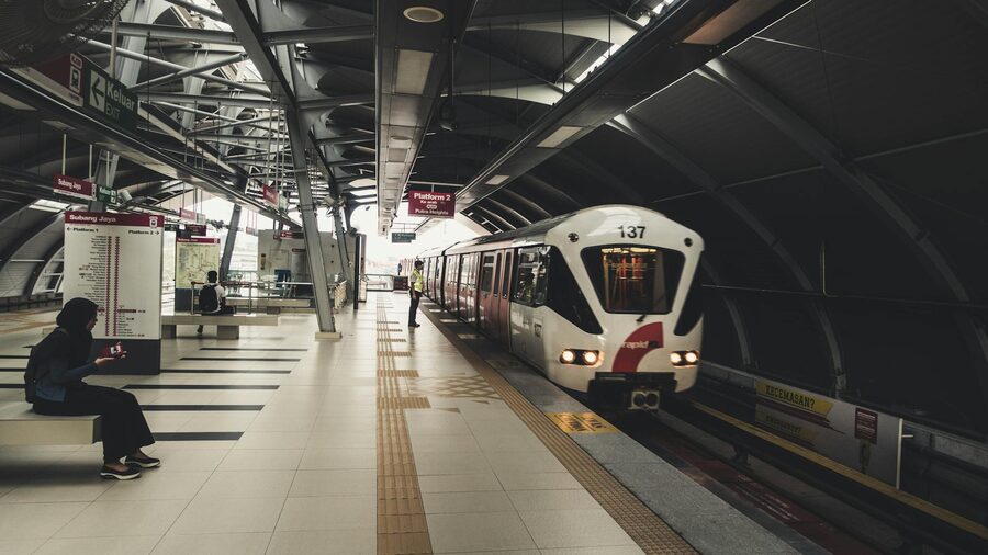A passenger waiting for a train at a modern railway station in Kuala Lumpur, Malaysia