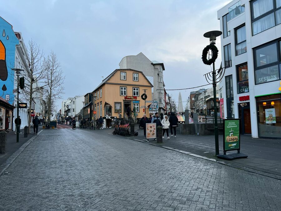 A street scene on Laugavegur in Reykjavik with people and shops under an overcast sky