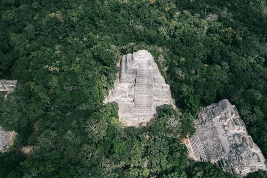 An ancient Mayan pyramid set in lush jungle, seen from the air