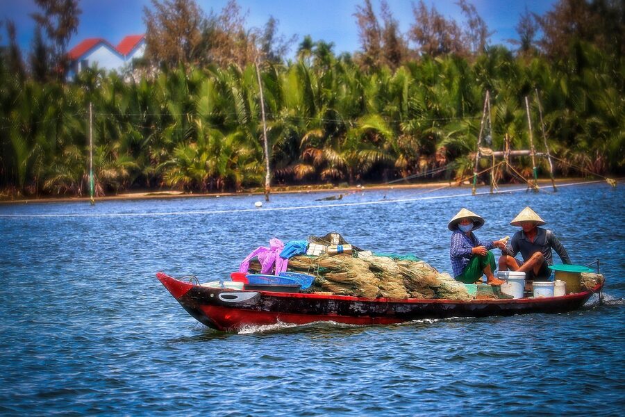 A fisherman in a cone hat on a boat in the Mekong Delta