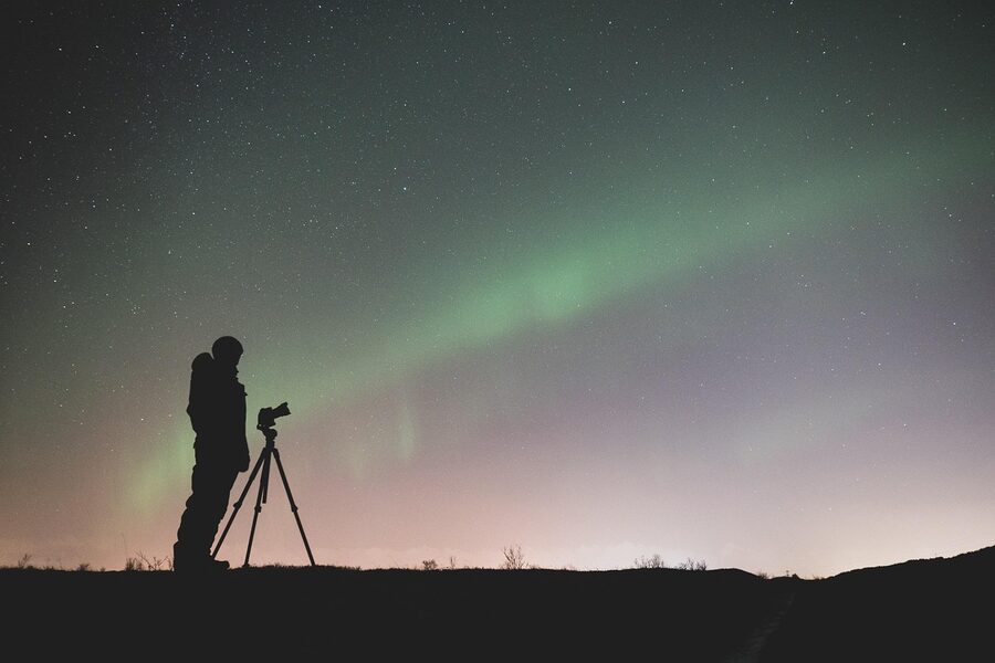 Silhouettes of photographers shooting the aurora borealis in Iceland