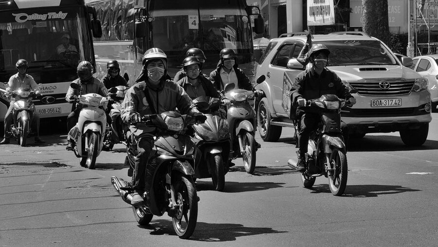 Motorbikes in Saigon street traffic with helmeted riders