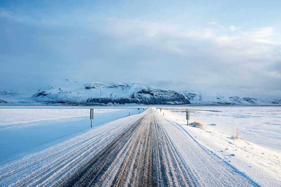 Snow-covered road leading to mountains at Vik i Myrdal, Iceland
